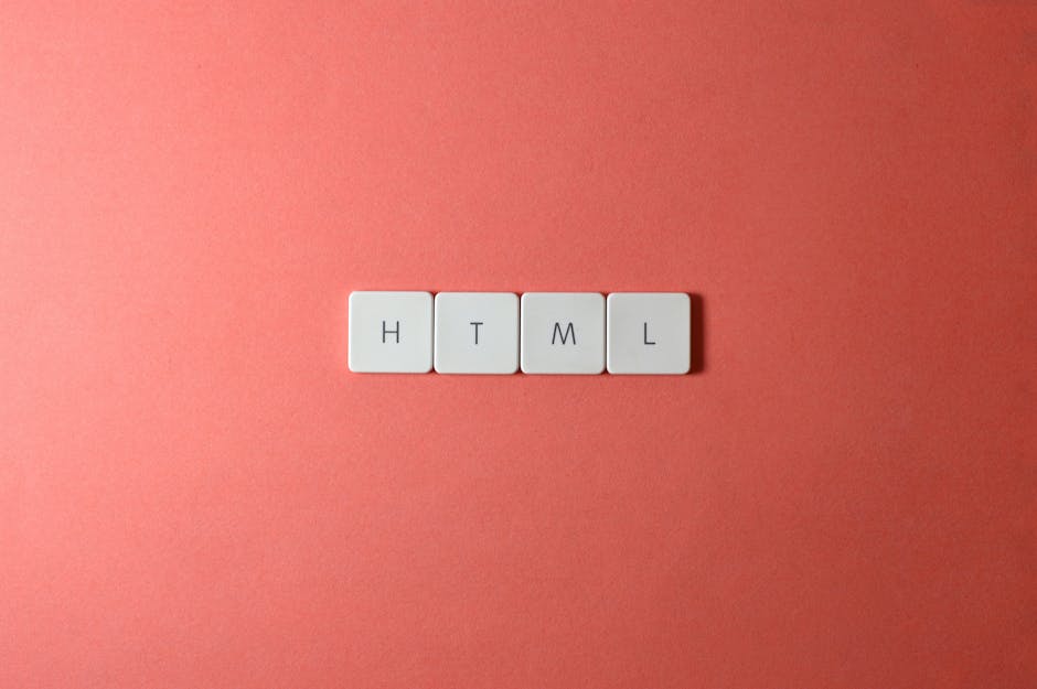 A close-up photograph showing four white square tiles placed in a straight horizontal line on a smooth pink background. Each tile features a black letter spelling out 'HTML'. The lighting is even, hig
